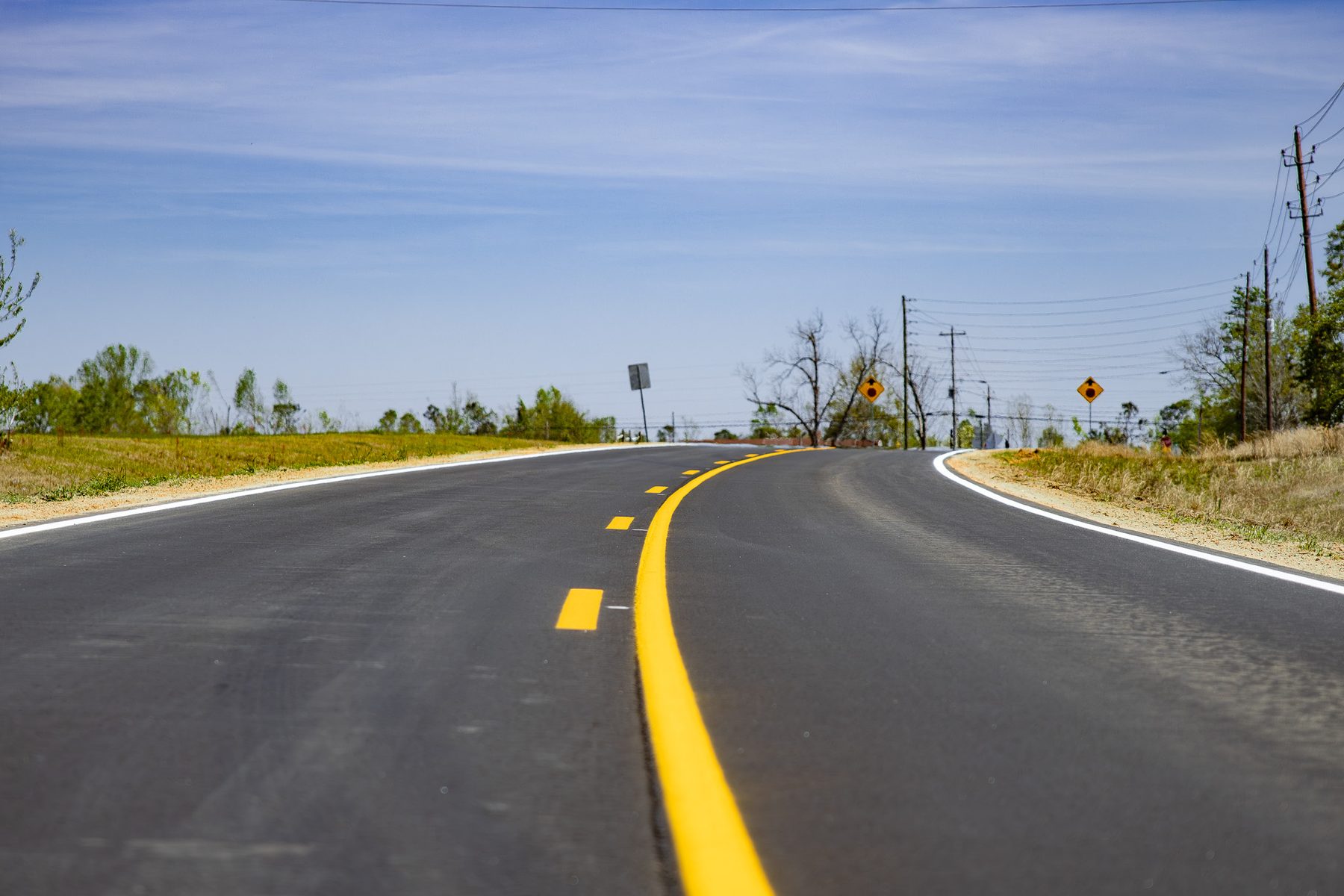 Newly paved curve with fresh striping on Saw Mill Rd in Mount Vernon, GA.