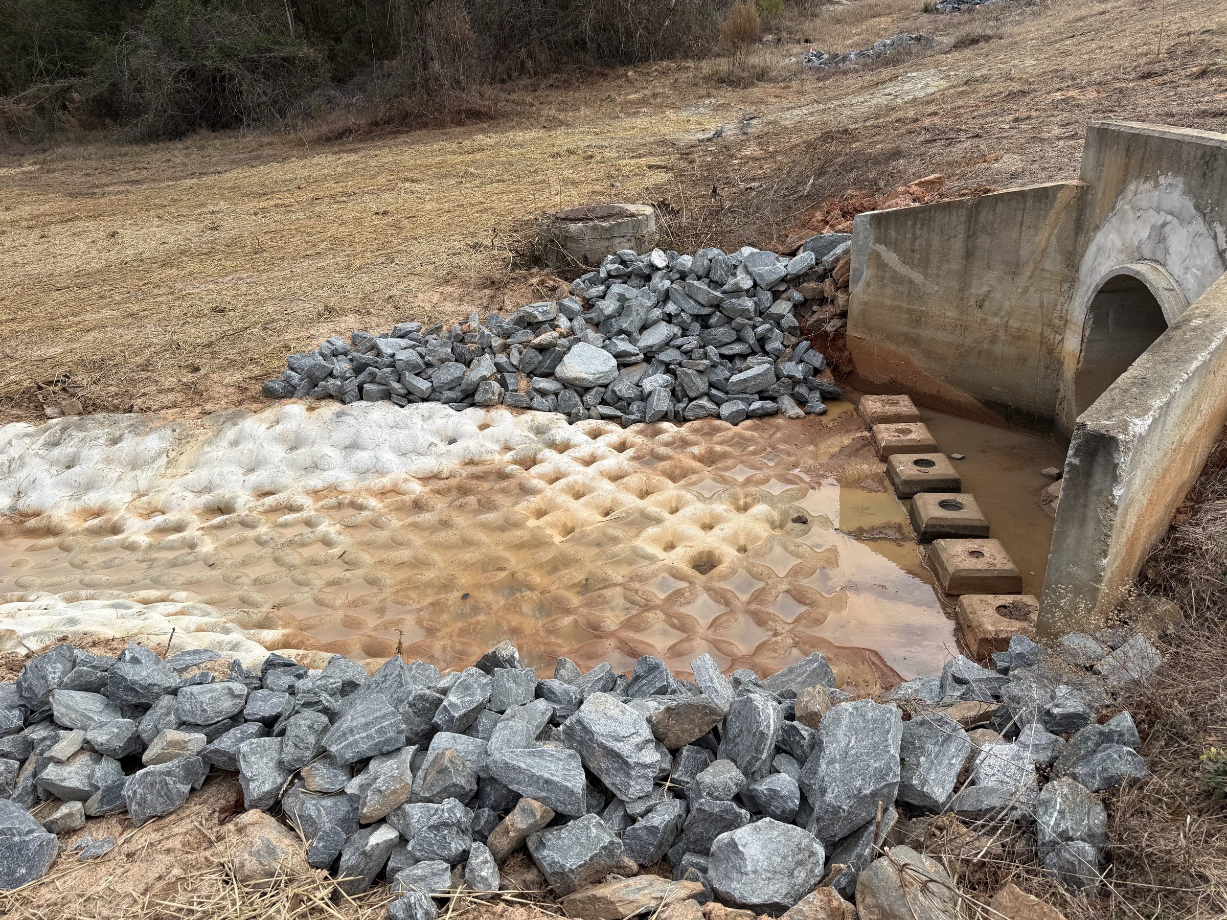 Close view of culvert headwall and riprap apron with concrete revetment in Perry, GA.