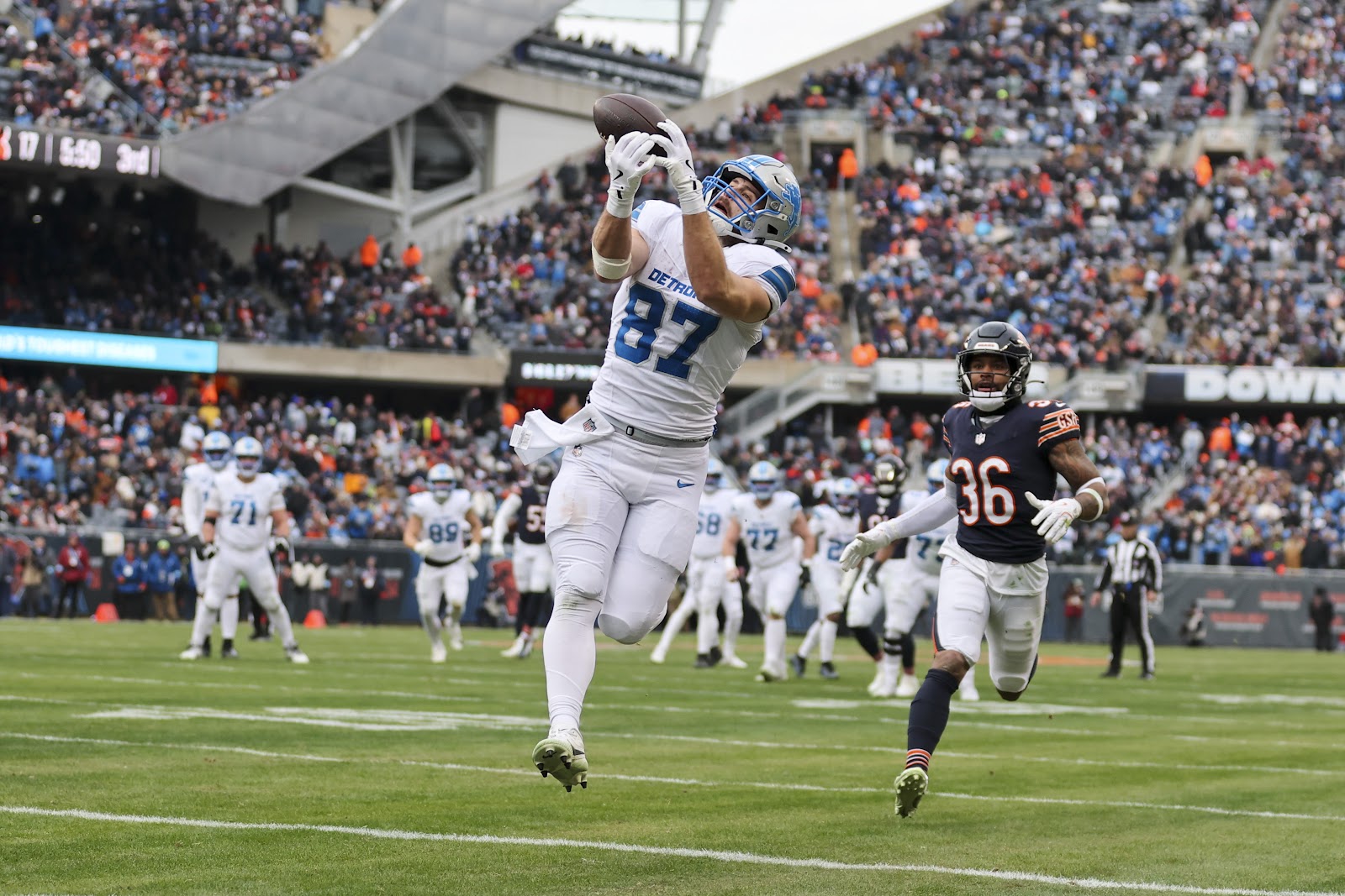 Sam LaPorta (87) kan de football securen voor een touchdown tegen de Bears op Soldier Field.
