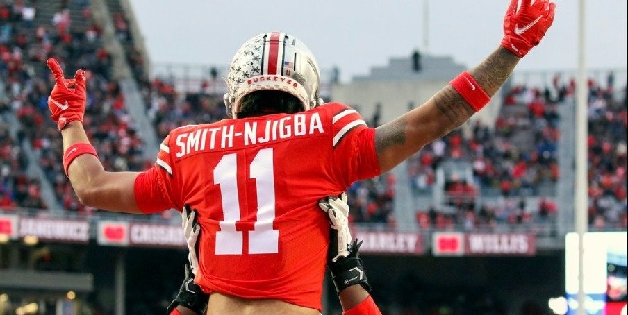 Jaxon Smith-Njigba (11) wordt op handen gedragen door zijn Ohio State team mates.