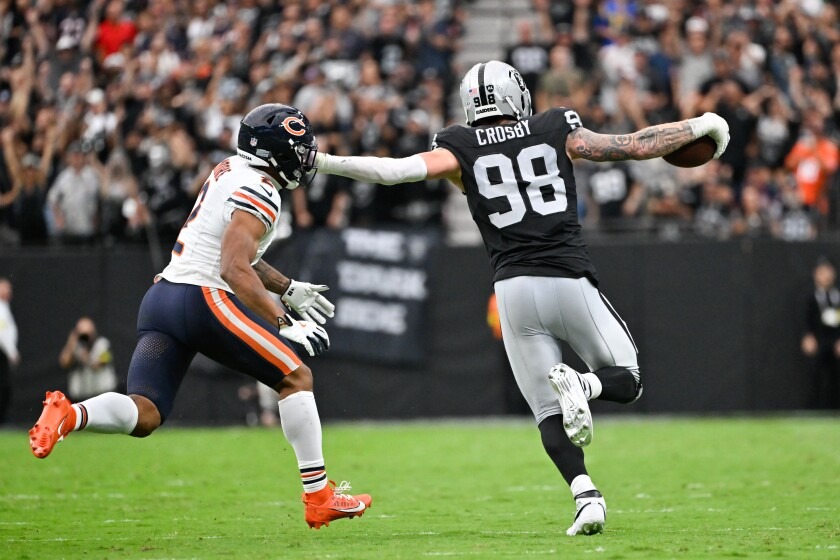 Maxx Crosby (98) die met de football richting de endzone van de tegenstander loopt voor een defensive touchdown.