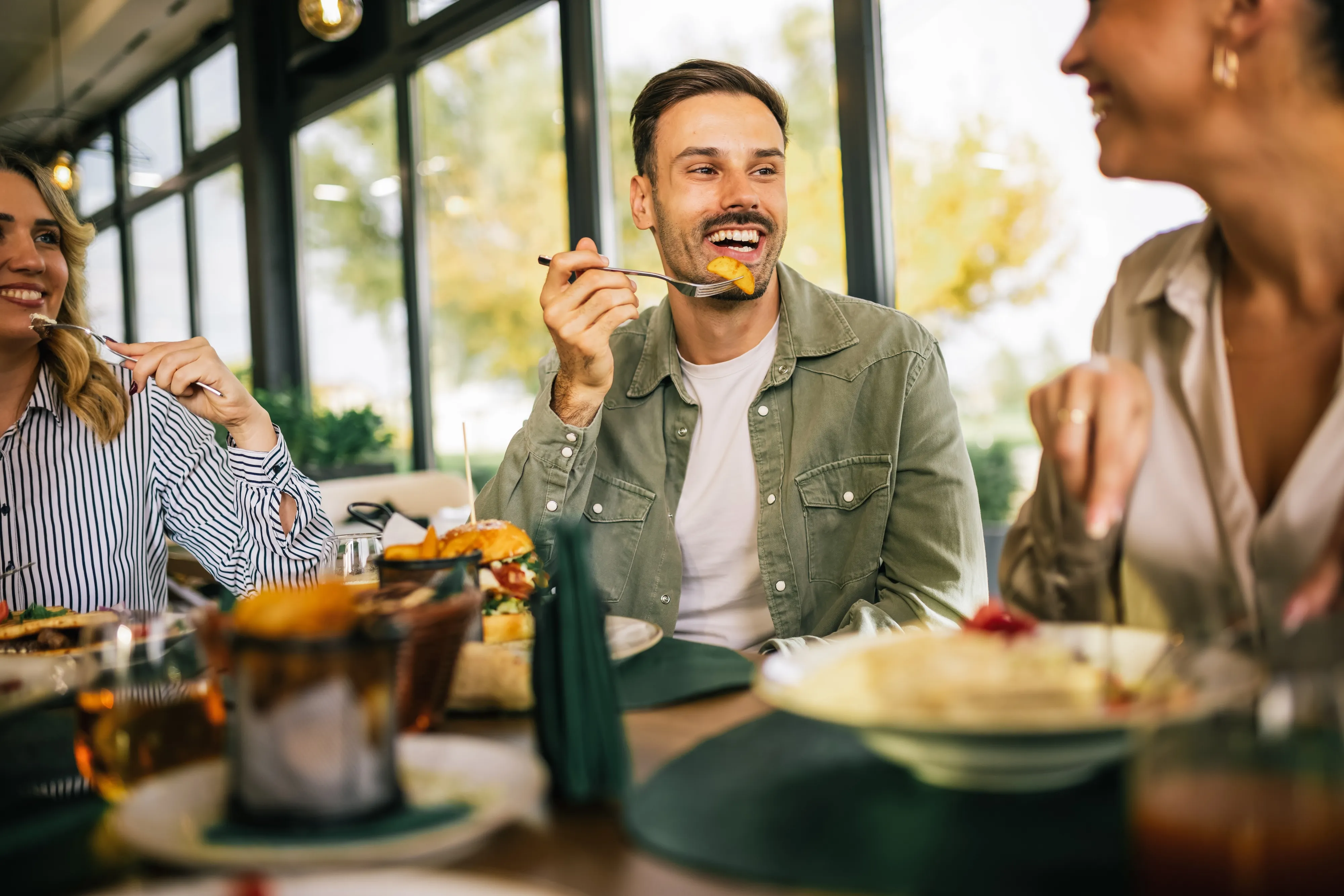 Friends enjoying lunch at a modern restaurant near Arbor at Riverstone apartments in San Antonio, TX