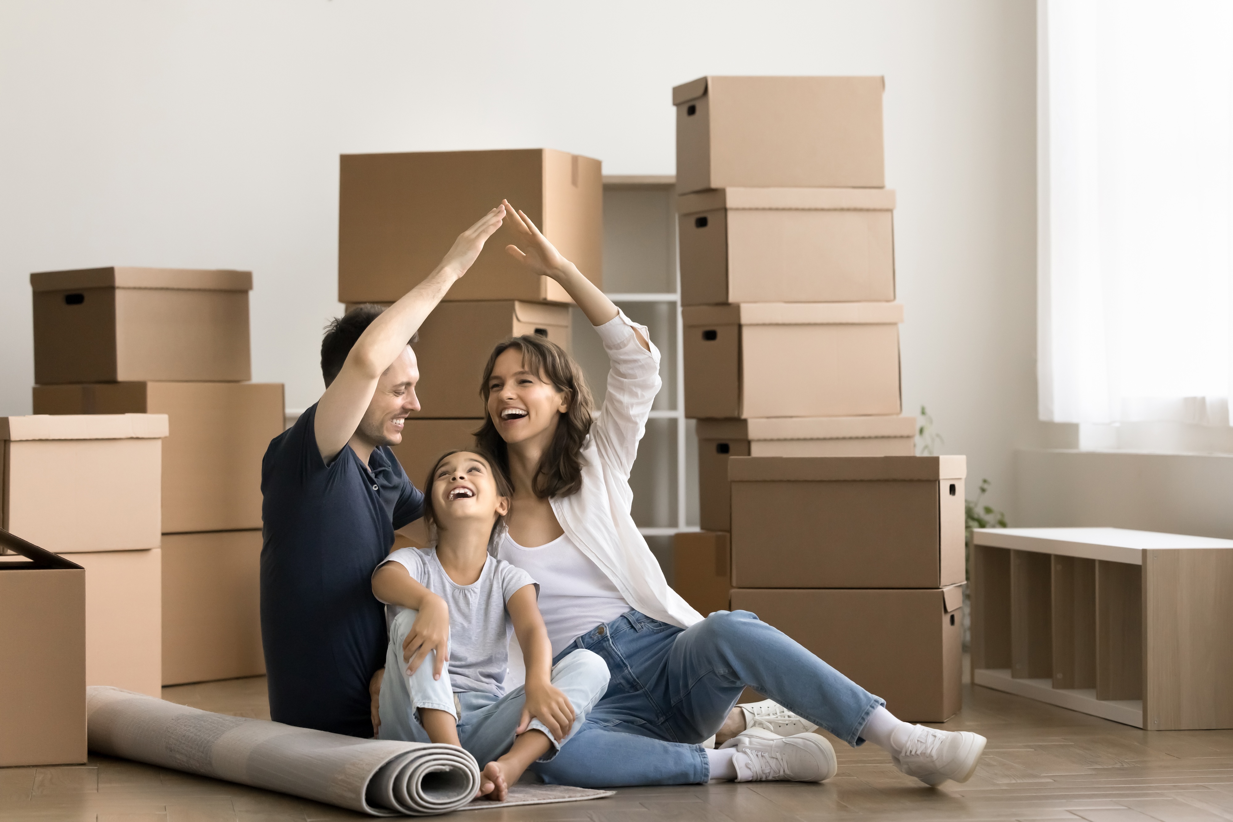 Happy family moving into rental home surrounded by moving boxes
