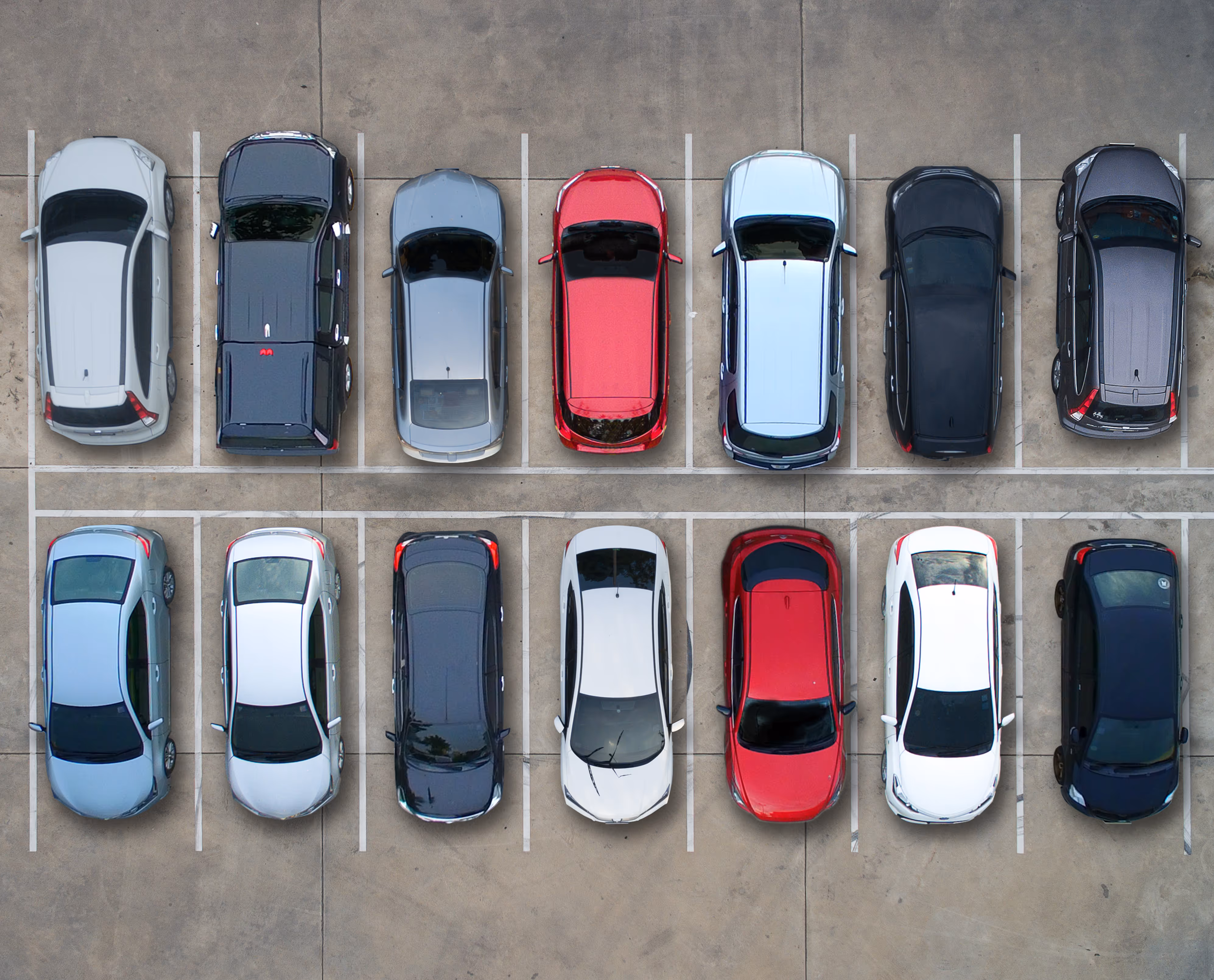 Overhead view of two rows of twelve diverse cars (various colours and models) parked in an empty asphalt lot.