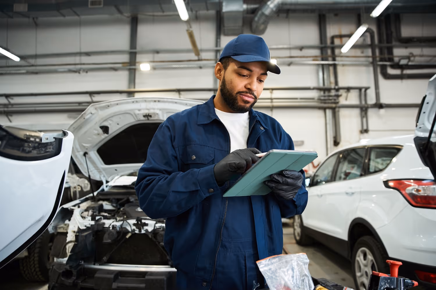 A technician in a auto shop double-checking details on a clipboard.
