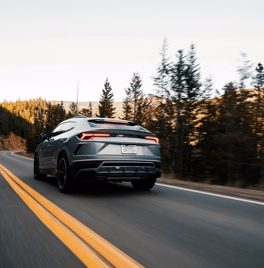 A modern SUV driving across the backdrop of forests in Ontario, Canada