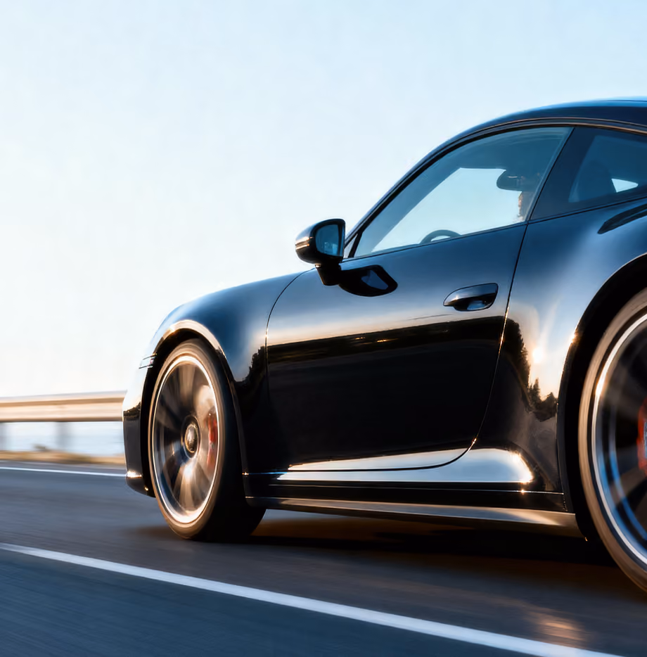 A long angle of a modern black car driving on a highway.