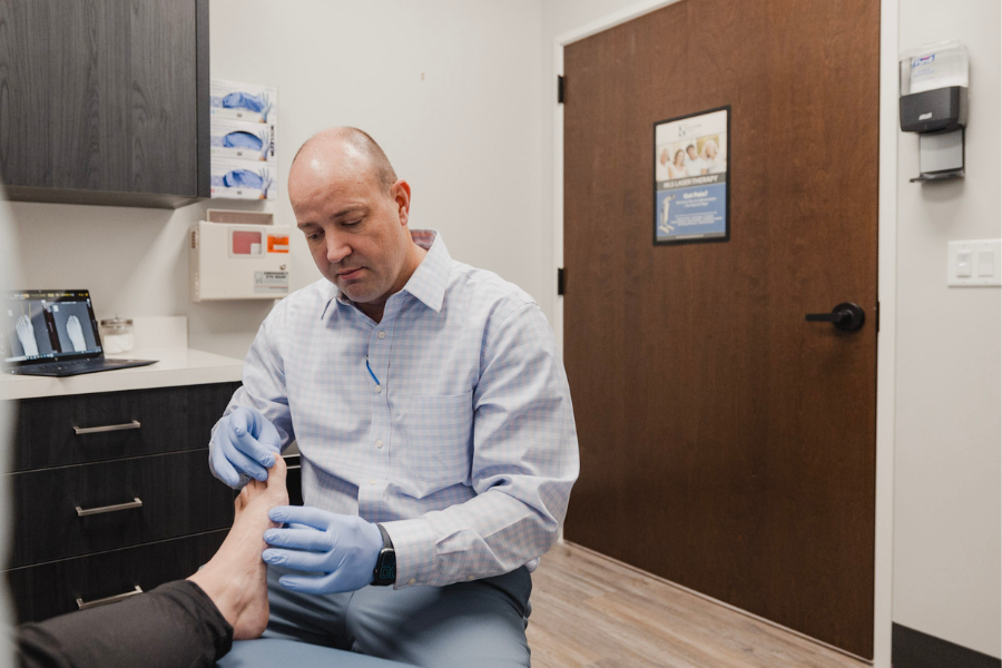 Podiatrist evaluating a patient’s ankle during a clinical foot and ankle exam.