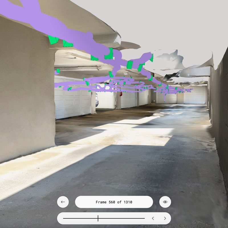 Polycam walkthrough mode interface at frame 560 of 1310, displaying a garage corridor with the camera path visualization overlay. The purple stroke shows the 3D trajectory of the camera movement through the space, with bright green markers indicating key capture points. The view shows concrete floors, white block walls on the right, and exposed ceiling structure.