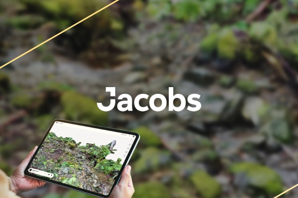 rocks and vegetation. The background shows a blurred natural landscape with plants and foliage, . The Jacobs logo appears in white text at the top.