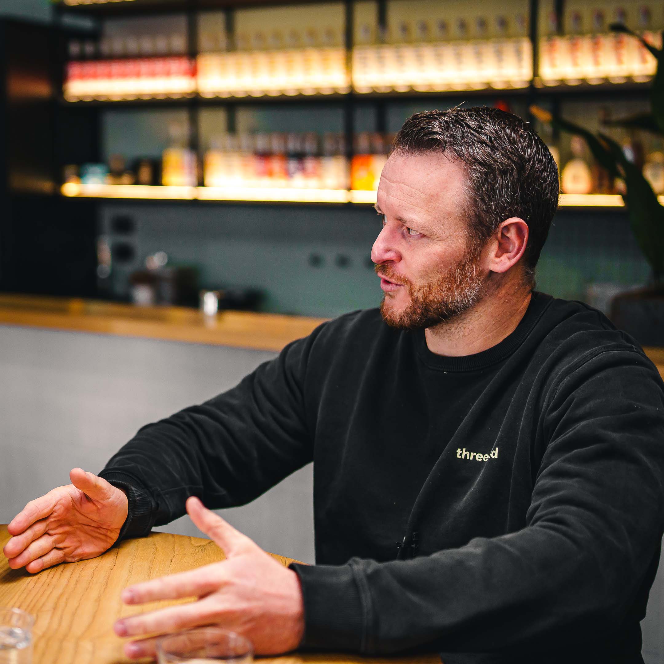 Two hands, raising a cocktail to one another