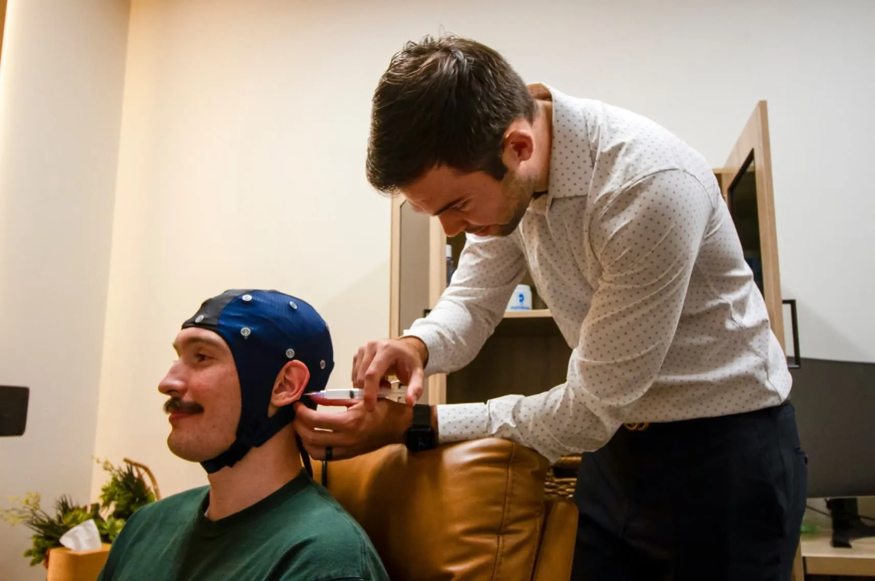 Brain Performance Neurofeedback Centers: Technician adjusting EEG cap for assessment