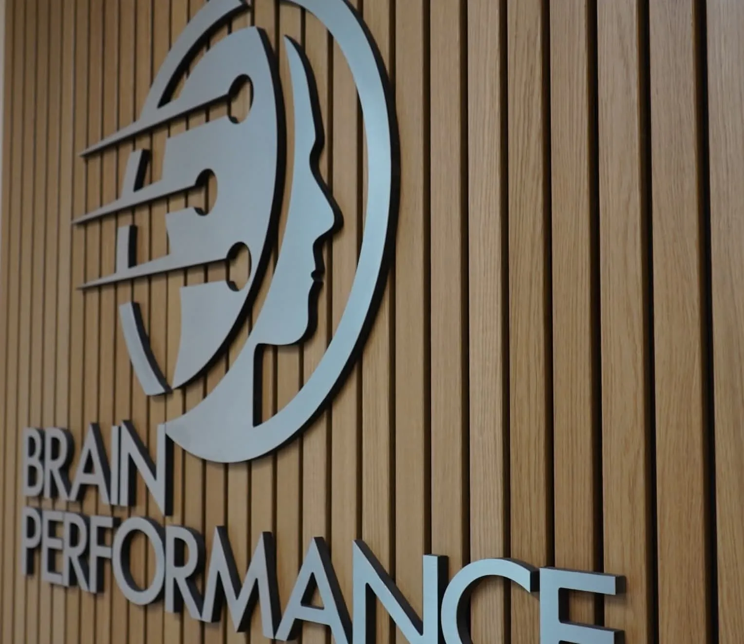 Brain Performance Neurofeedback Centers logo on wooden panel wall