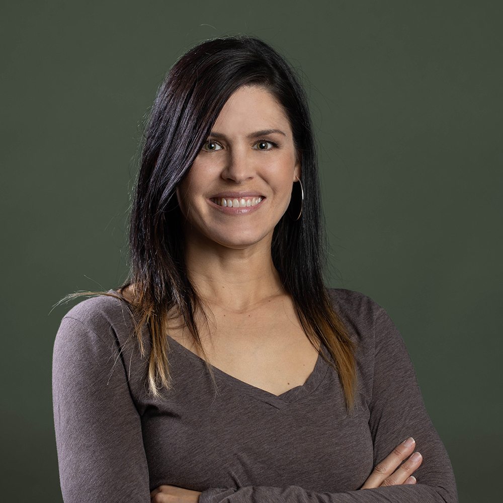 Brain Performance Neurofeedback Centers expert smiling confidently against green backdrop
