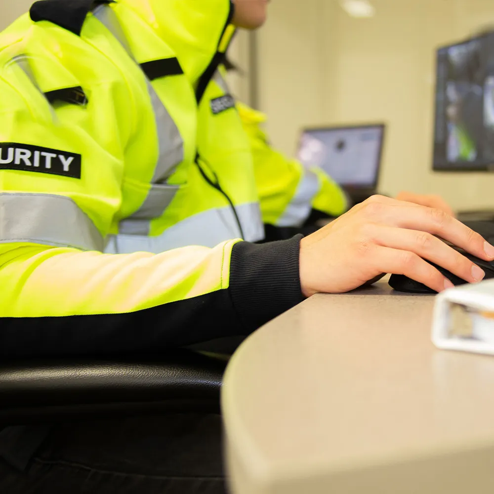 Das Foto zeigt eiinen Security-Beamten beim beobachten der Kameras.