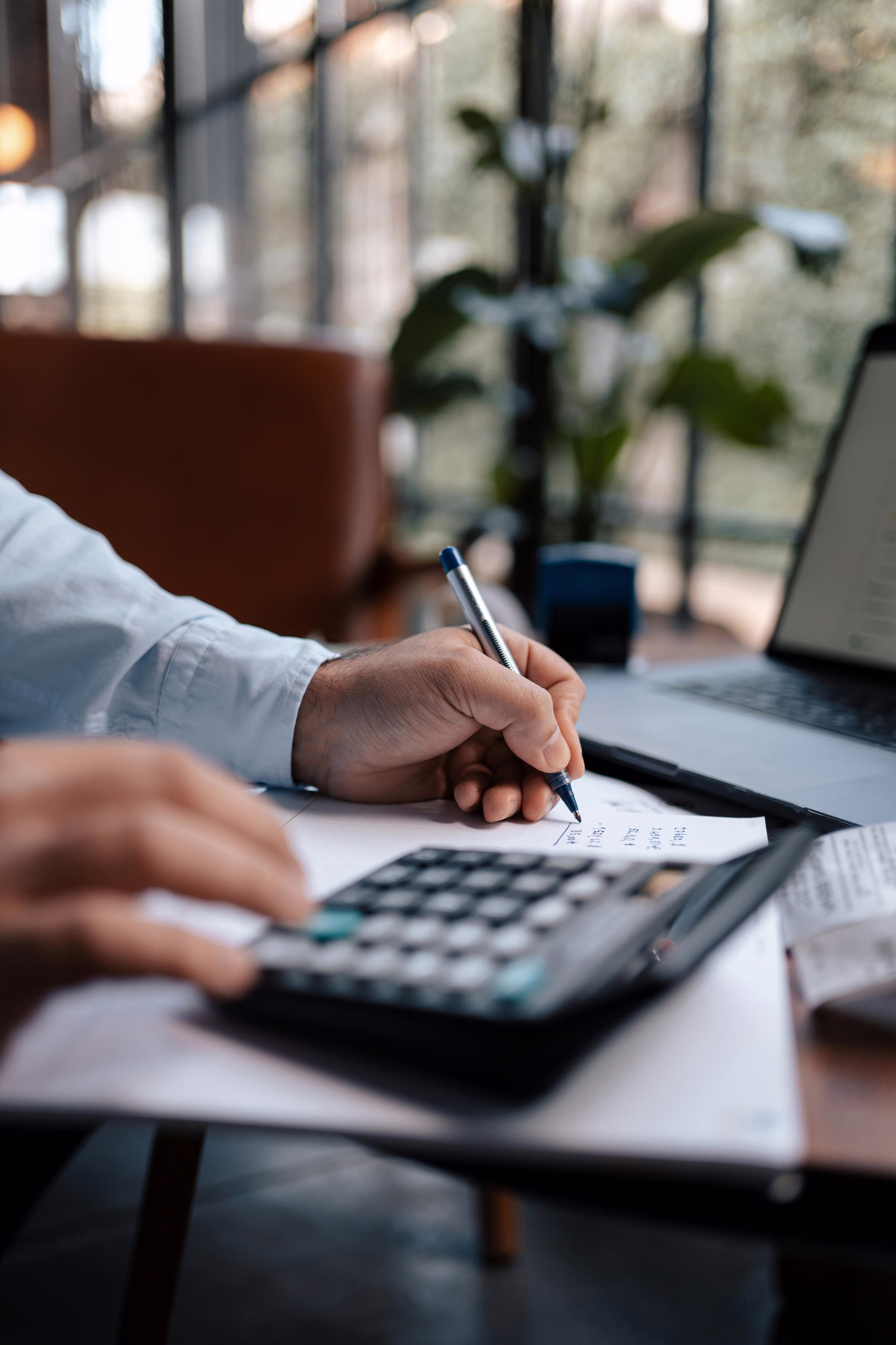 Man working in the some calculation using calculator and notebook