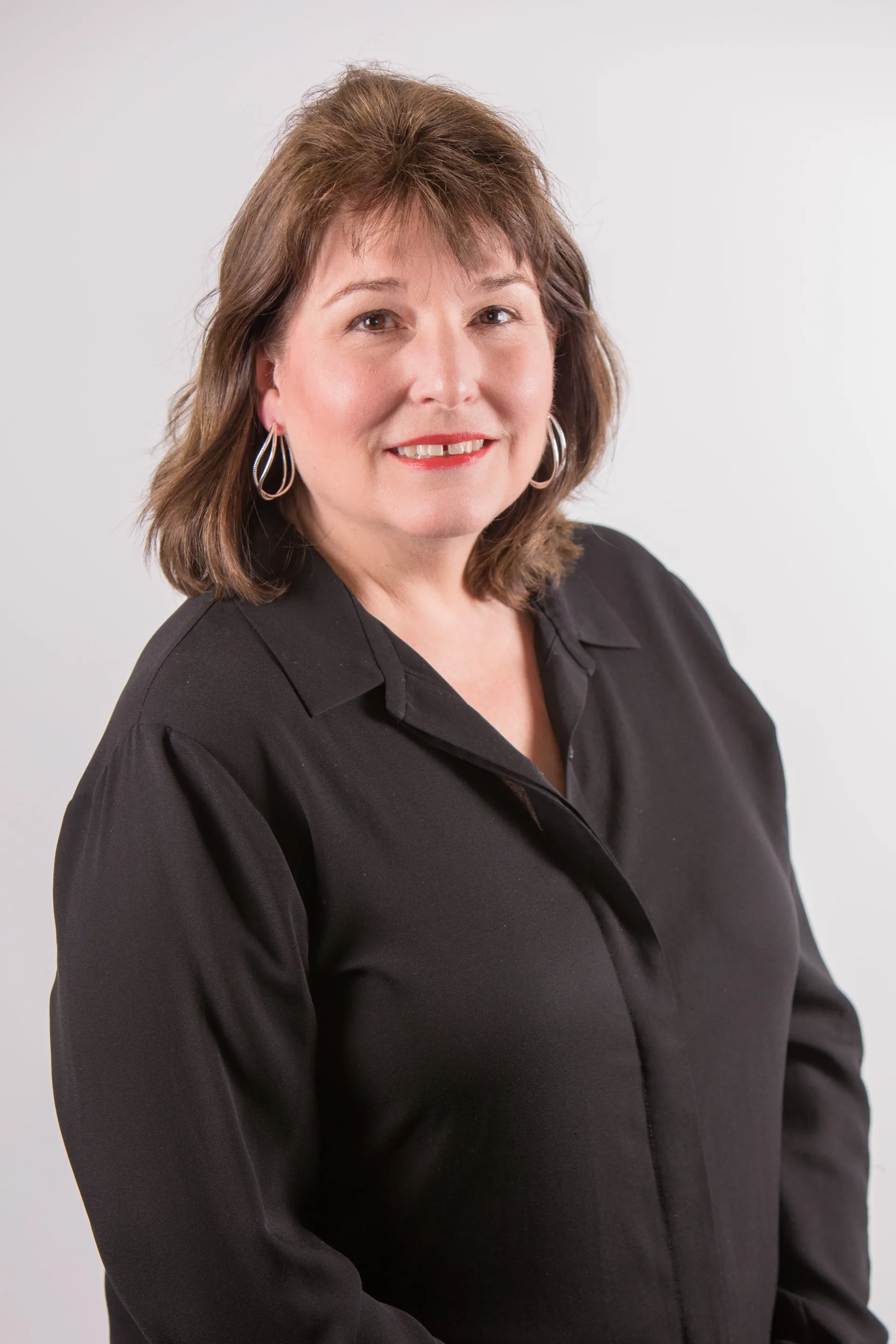 Professional headshot of Lorianne Smith, Director of Architecture at Jewett Construction, wearing a black blouse, smiling. She has over 30 years of expertise in Senior Living, Automotive, and Multi-Family design.
