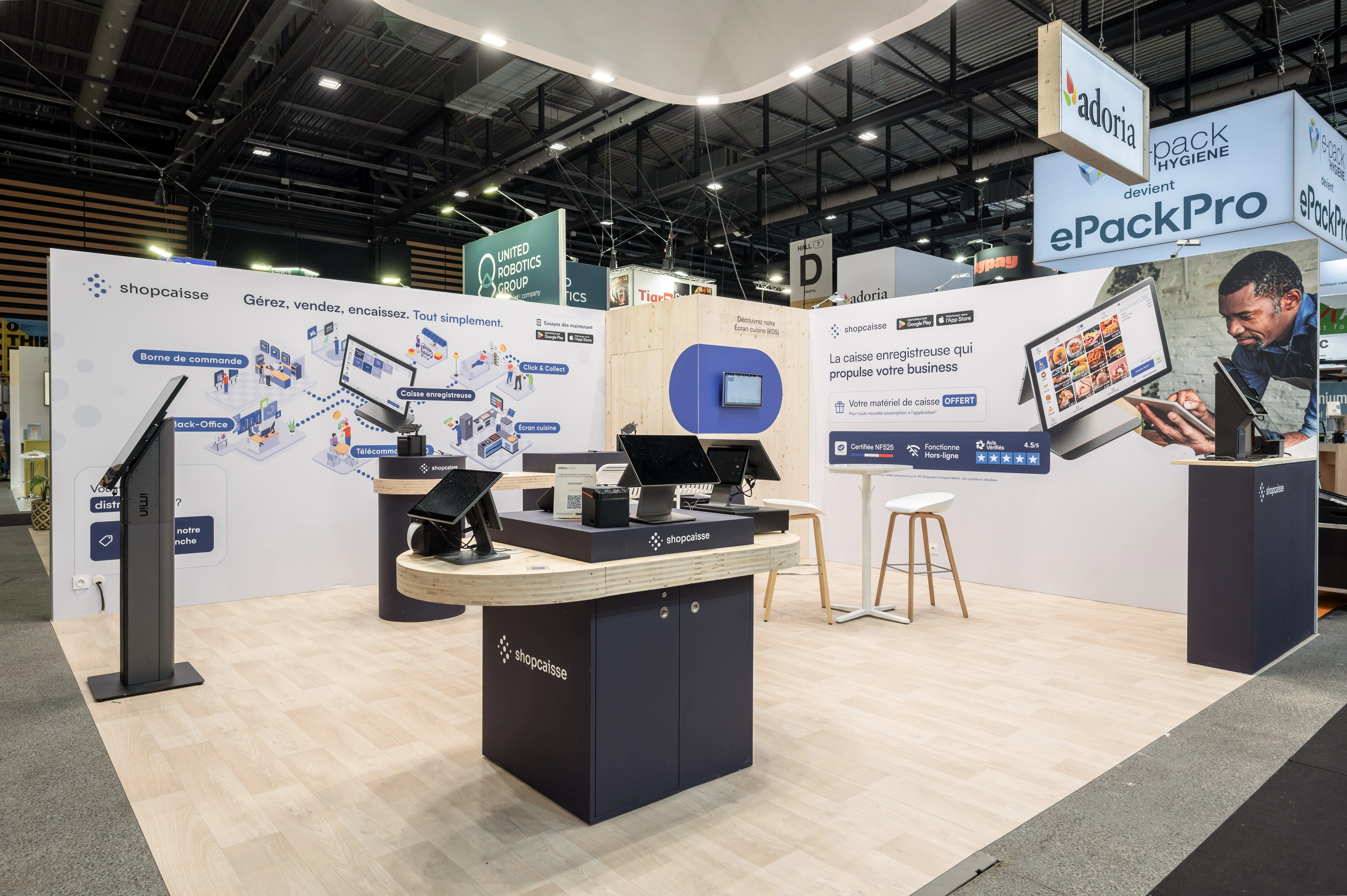 Stand d'exposition Shopcaise avec stations de caisse enregistreuse et écrans tactiles dans un salon professionnel.