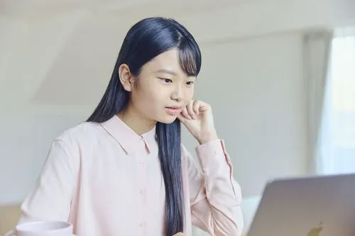 中学生がパソコンを見ながら、勉強している様子