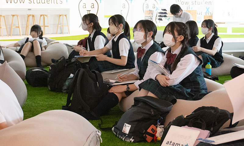 プレゼンテーションに聞き入りメモを取る高校生の様子。