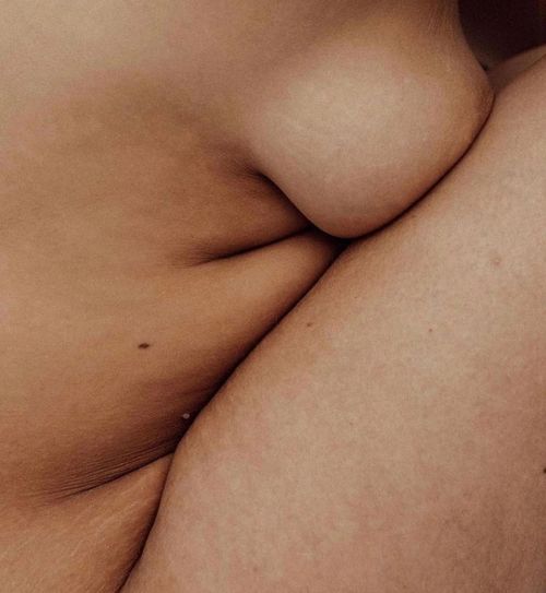 Someone's fleshy body with their chest to their knees.