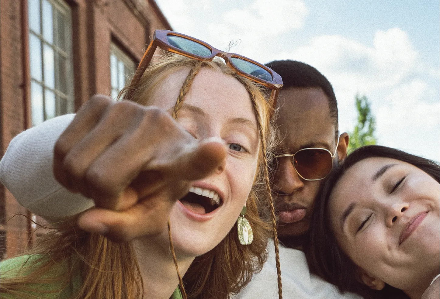 Drie jongeren die naar de camera glimlachen