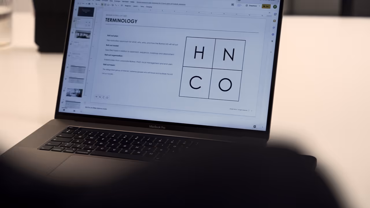 Billede af en MacBook Pro med HNCO-logoet synligt på skærmen, der viser en moderne og stilfuld bærbar computer.