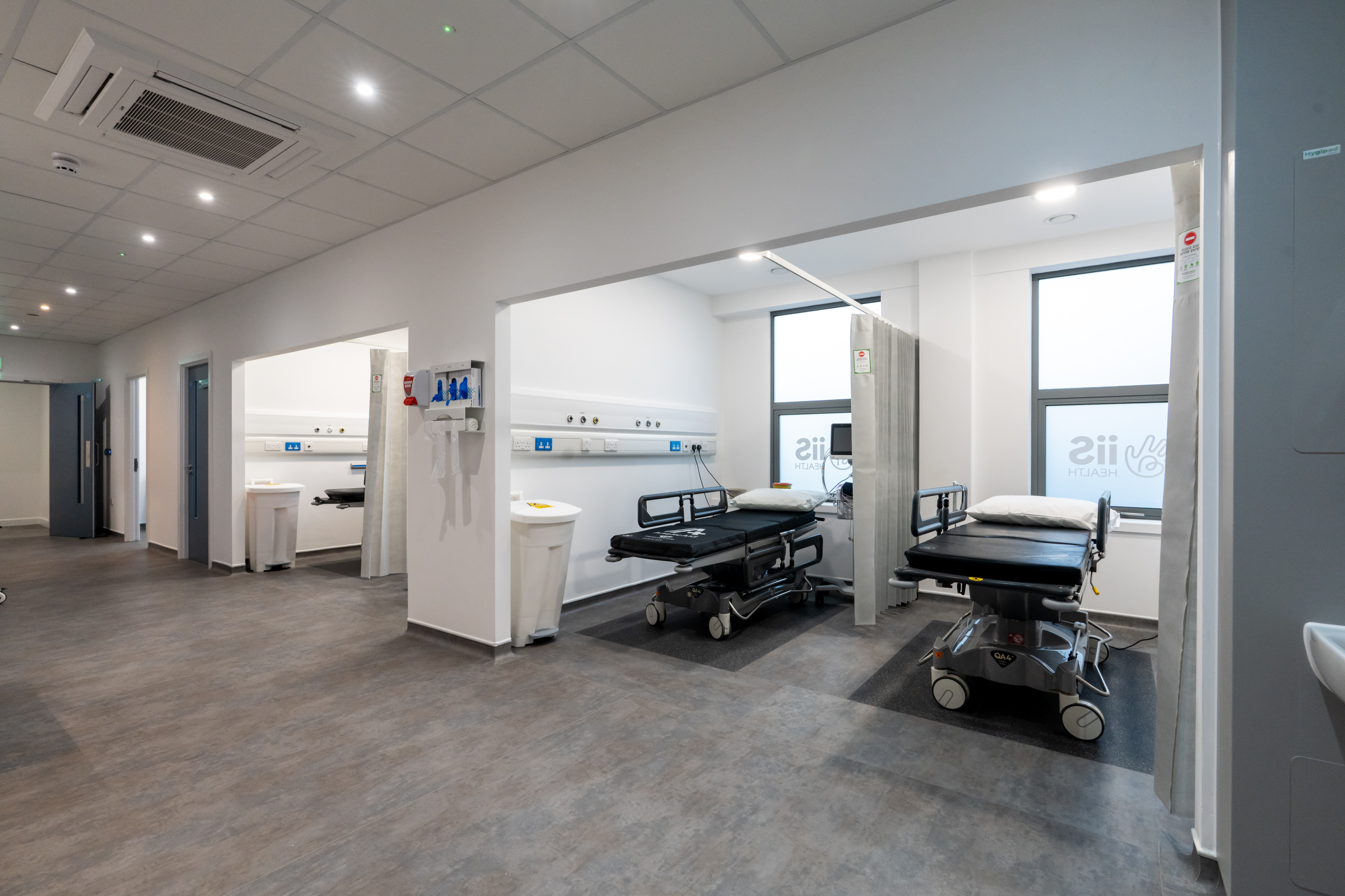 panned out photograph of the theatre recovery/block area with 2 bays each containing 2 theatre trollies and the theatre exit visible in the distance.