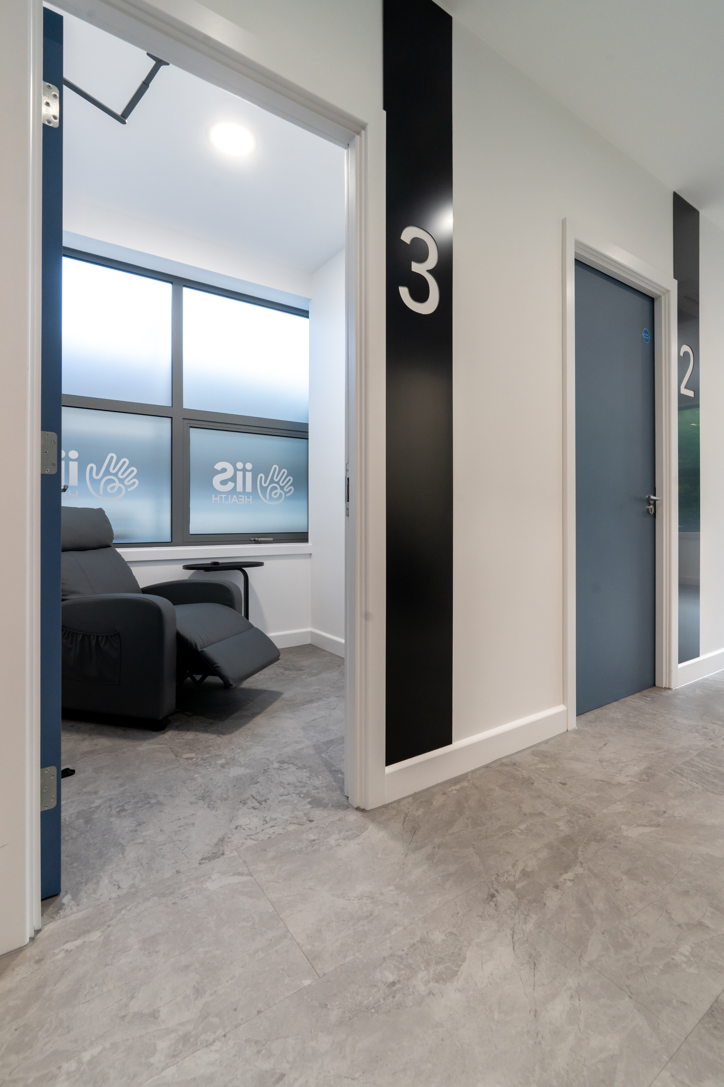 A photograph of pod 3 with the door open showing a recliner chair and coffee table in a private pod.