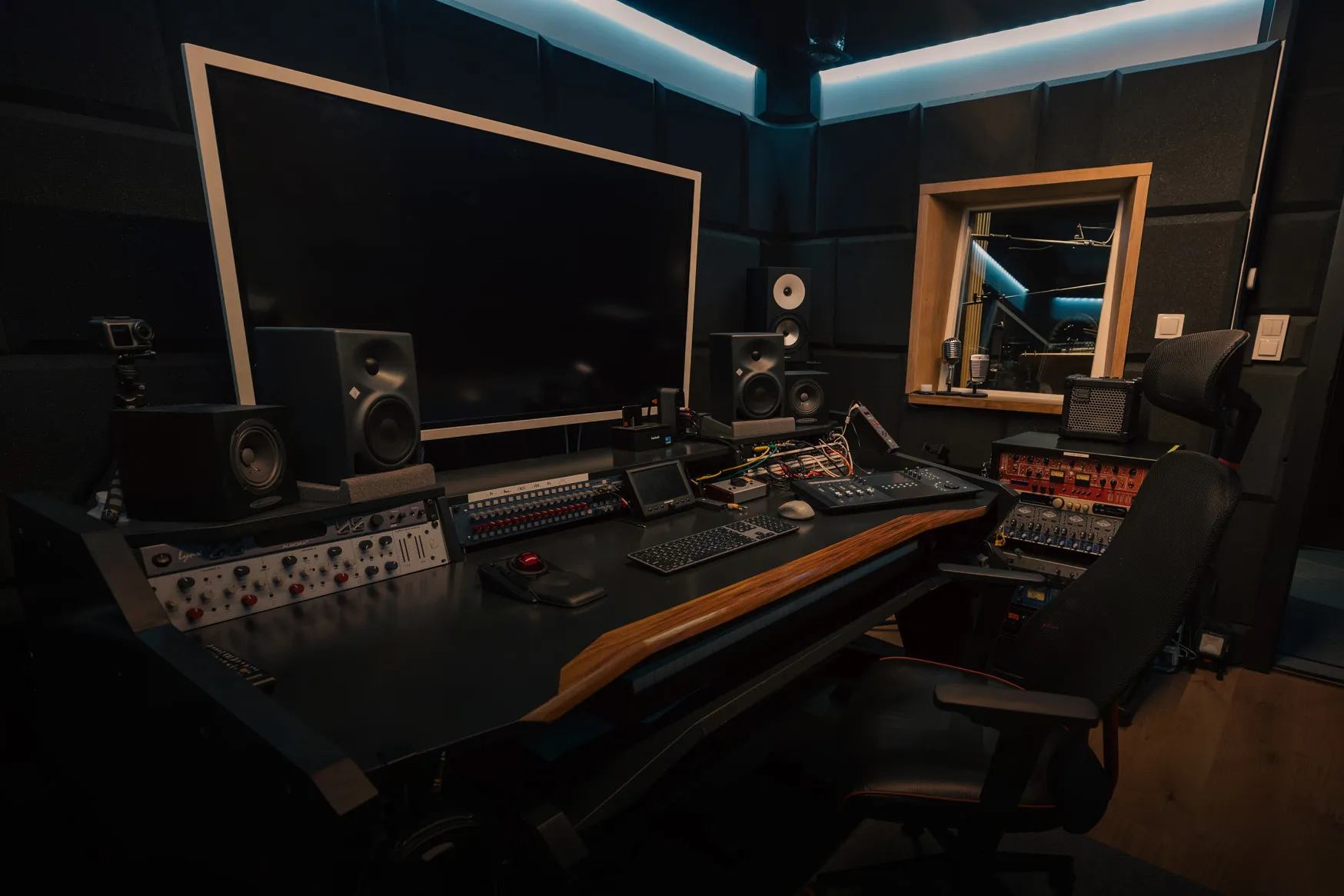 Nowoczesne studio nagrań z dużym monitorem, głośnikami studyjnymi, konsolą mikserską i ergonomicznym krzesłem na Elektronowej 10 w Warszawie.
