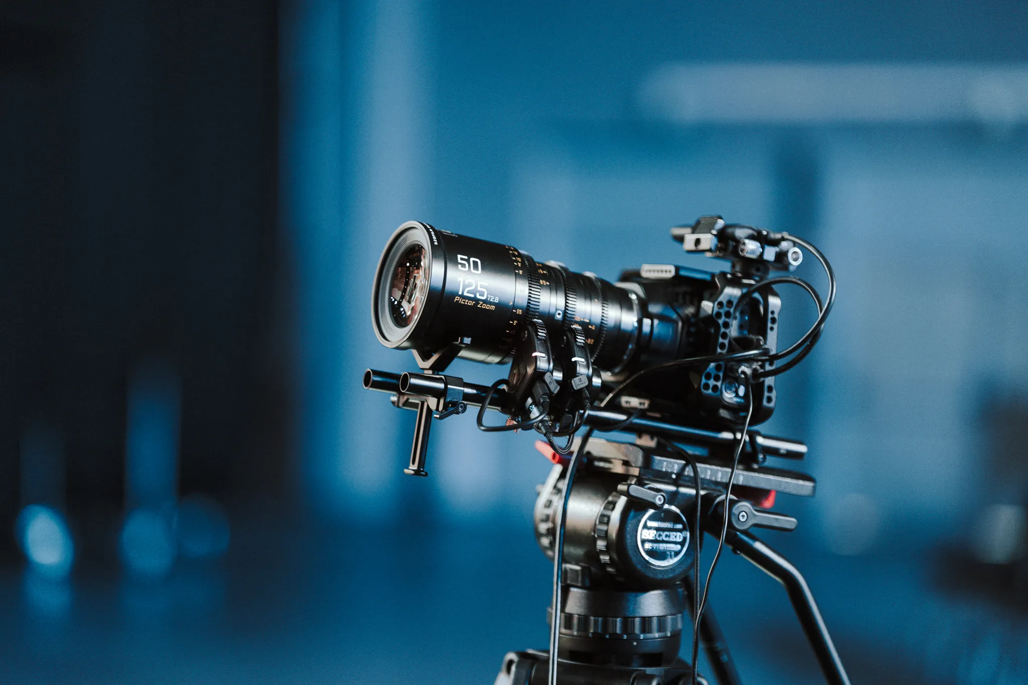 Profesjonalna kamera filmowa na statywie z dużym obiektywem zoom.