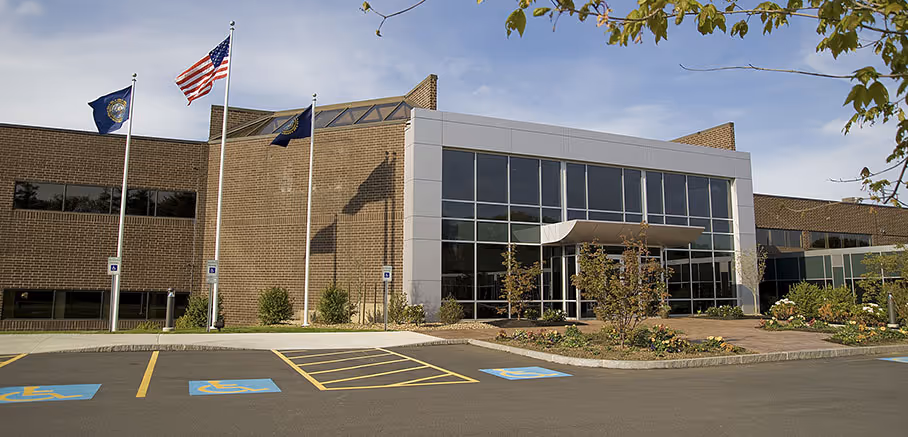 Modern brick office building with glass entrance and flagpoles in front