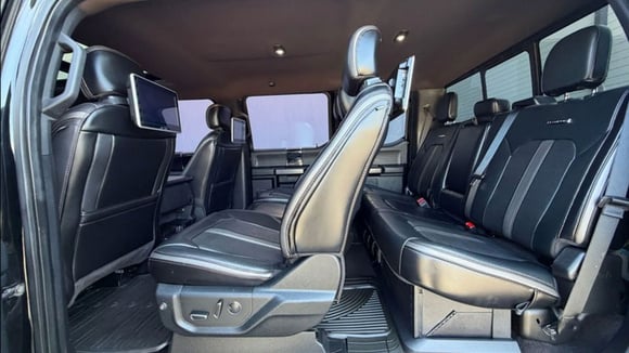 Habitacle d’un Ford F-450 étiré avec plusieurs rangées de sièges et portes antagonistes