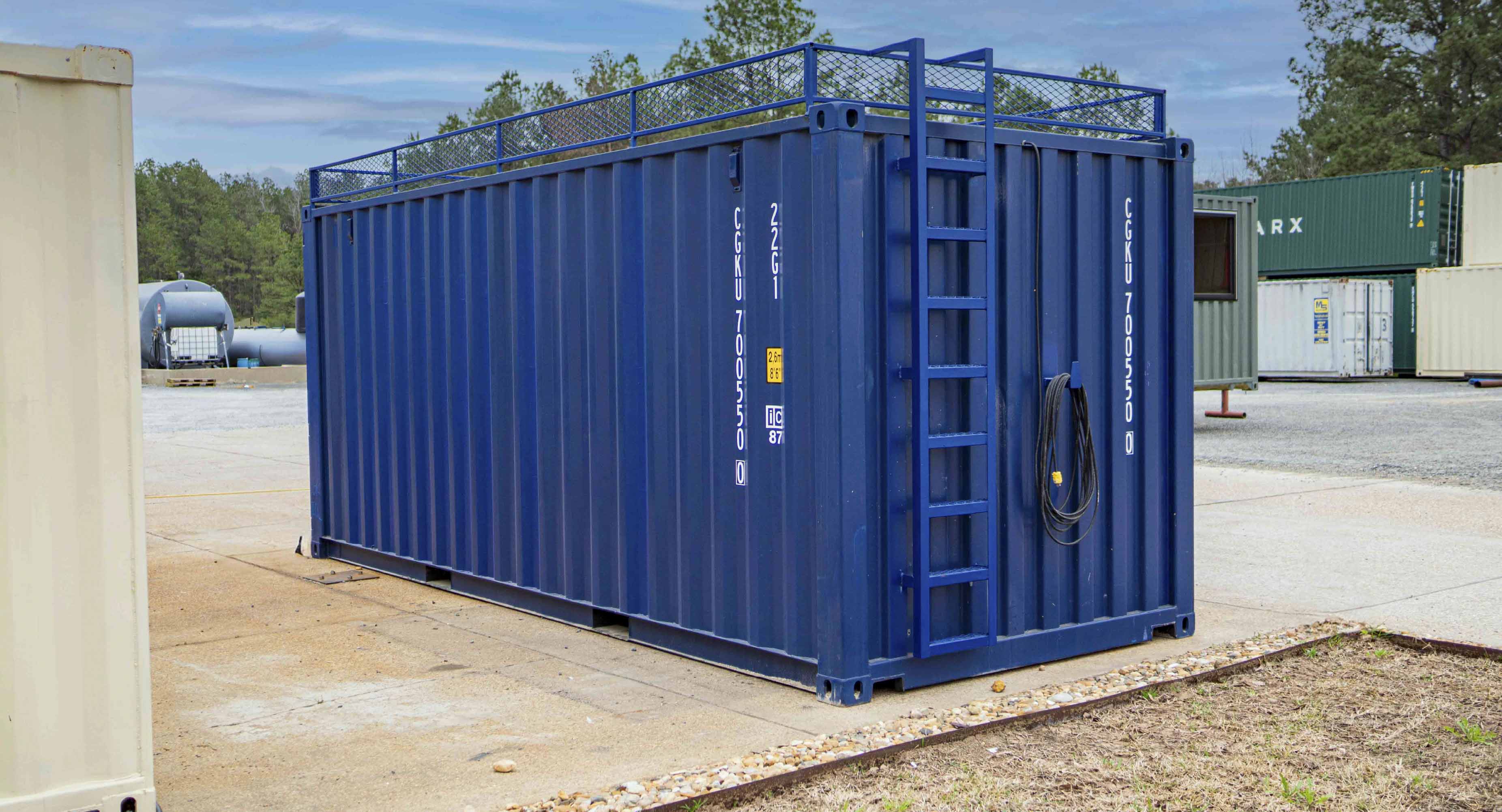 Blue modified shipping container with safety railing and ladder at oilfield support yard in North Louisiana for storage and logistics services