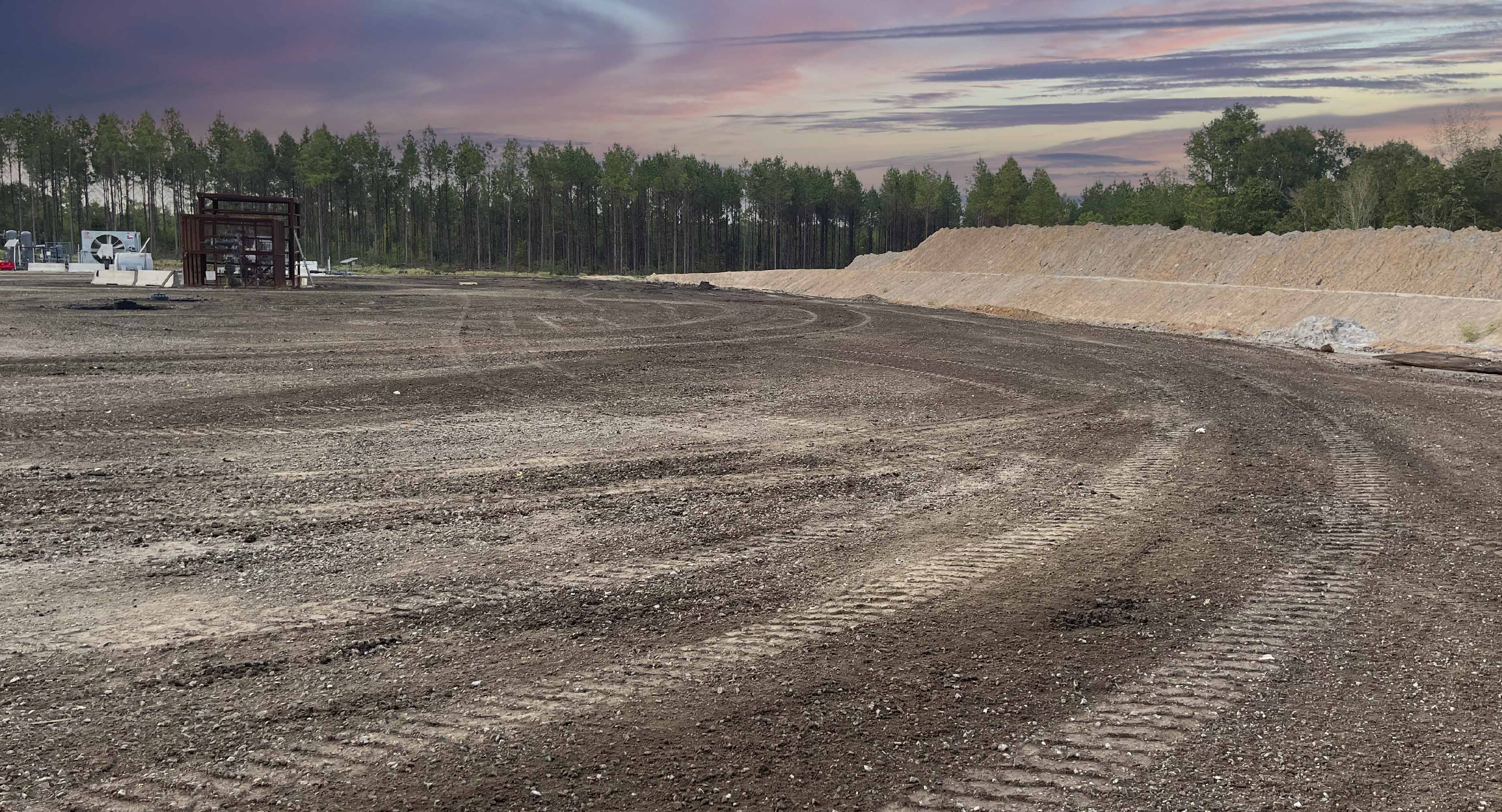 Graded oilfield location site with compacted dirt and berms ready for rig move-in and oilfield operations