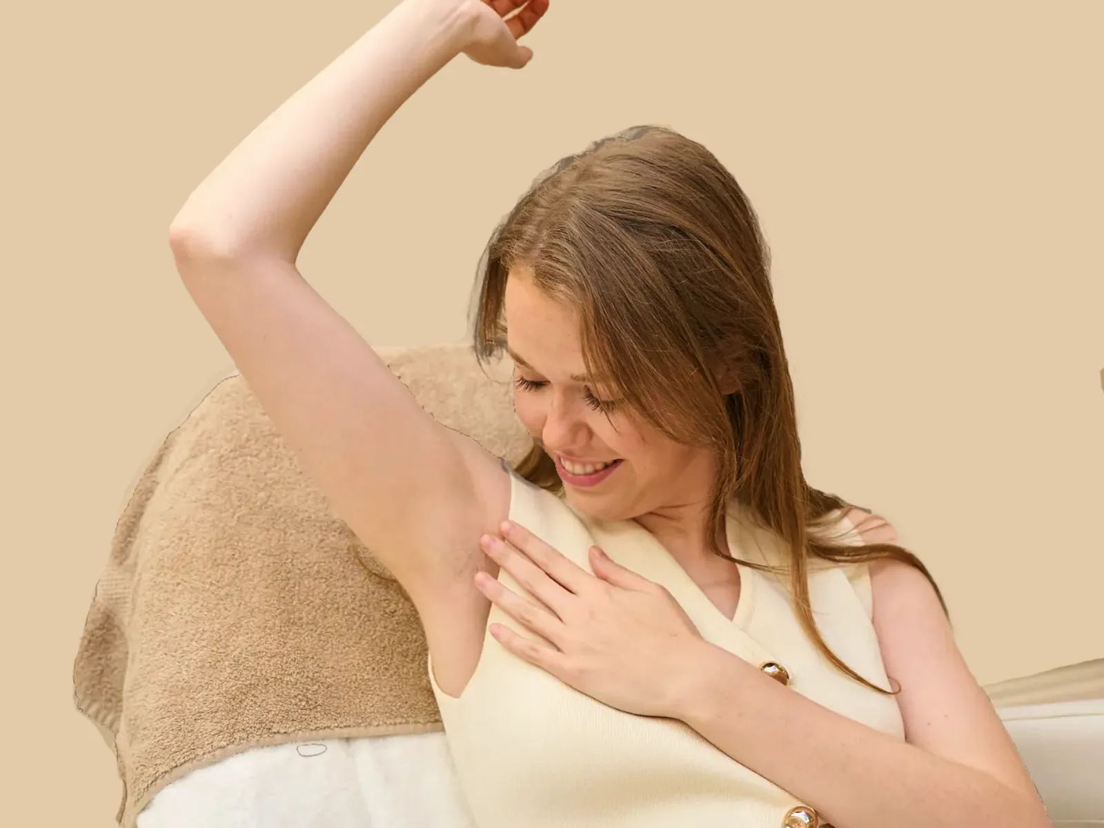 Lächelnde Frau zeigt ihre ungebräunte, haarfreie Achselhöhle, während sie ihre Hand darauf legt.