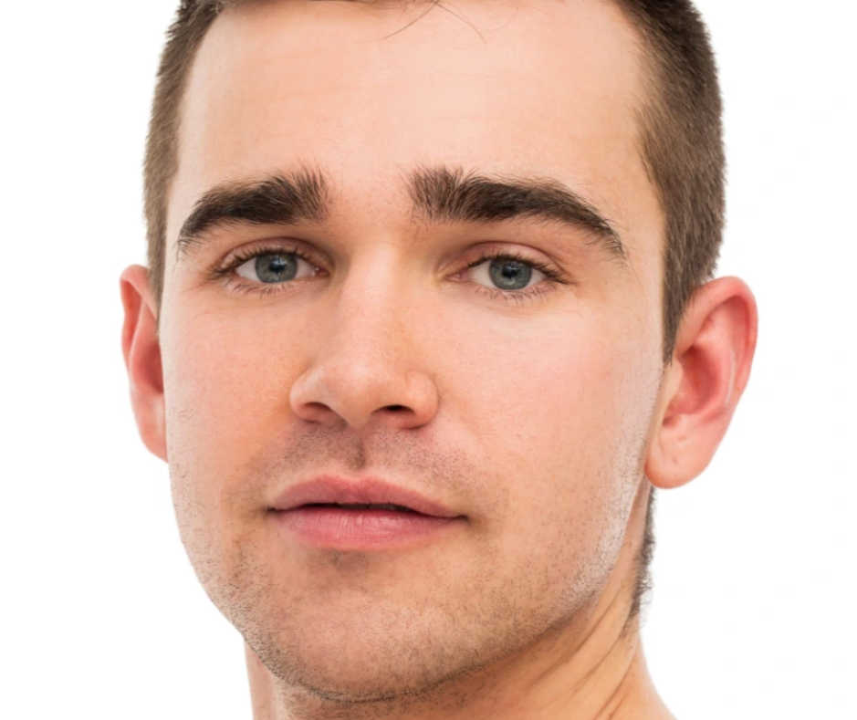 Nahaufnahme eines jungen Mannes mit kurzem braunem Haar und blauen Augen vor weißem Hintergrund.