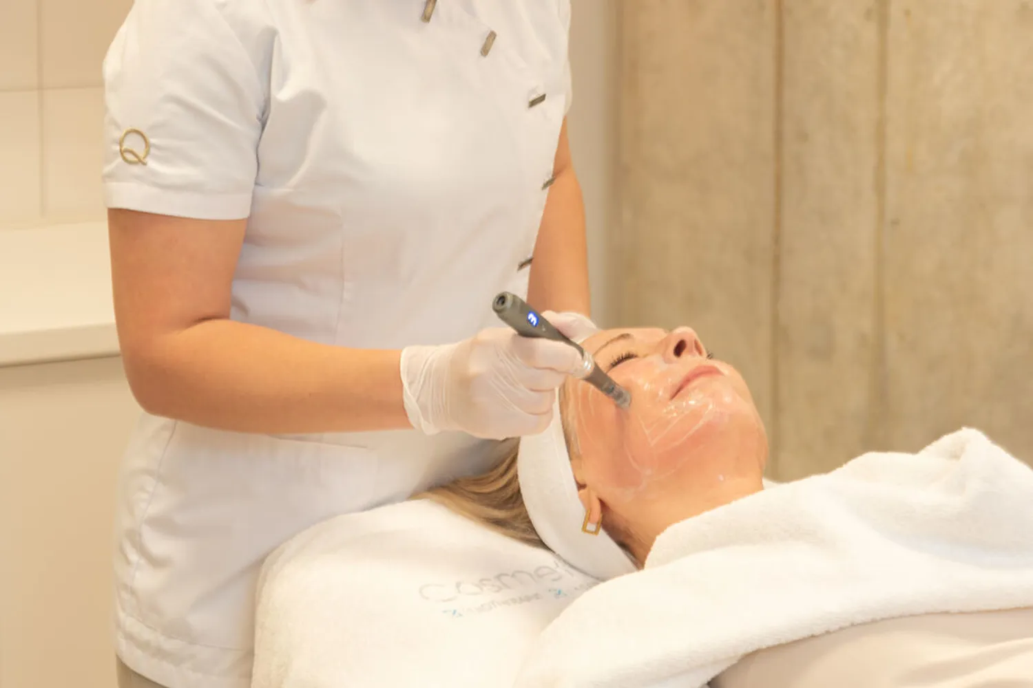 Kosmetikerin führt eine Hydrafacial-Behandlung an einem entspannten Patienten in einer Klinik durch.