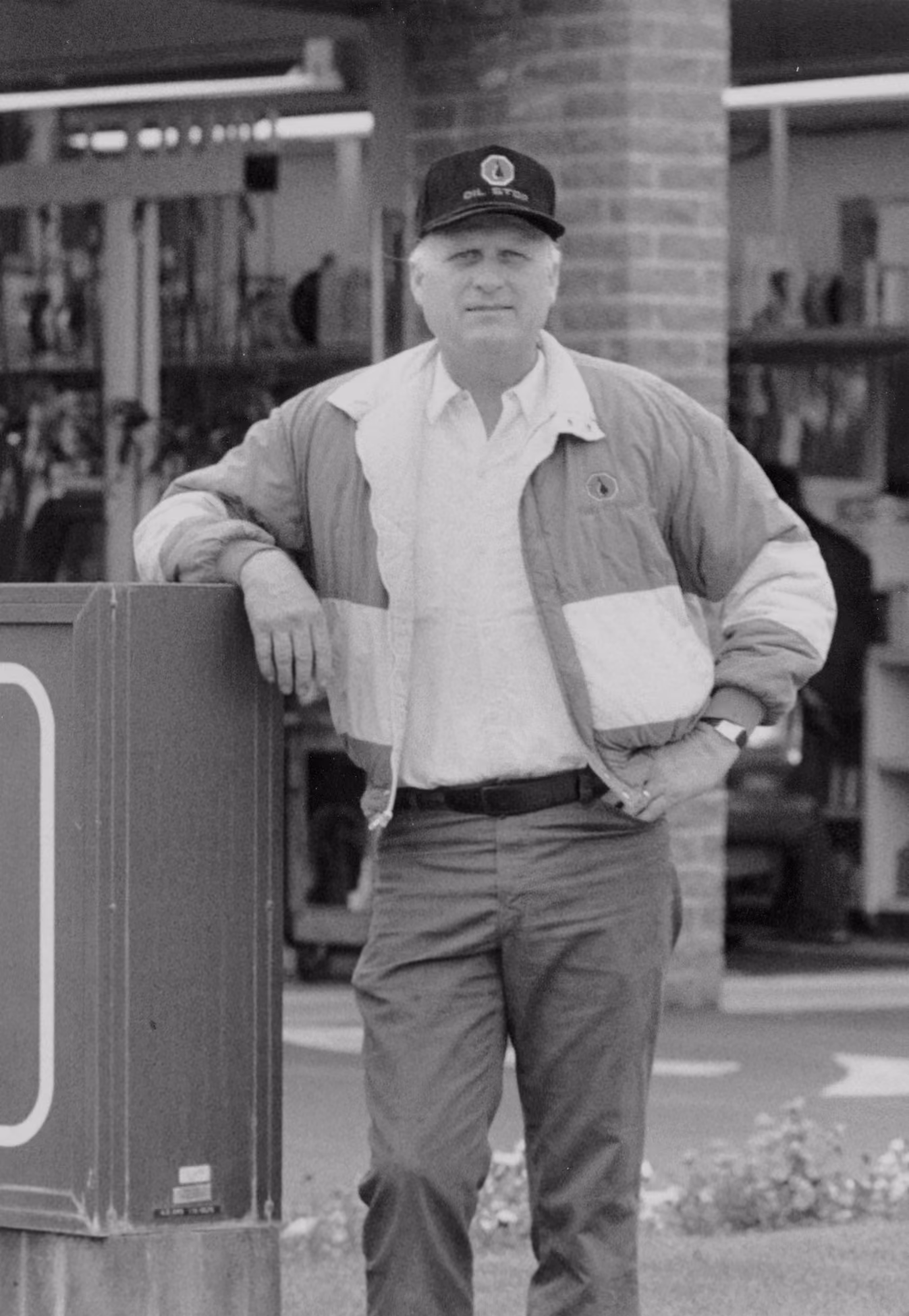 man leaning on wall wearing a cap