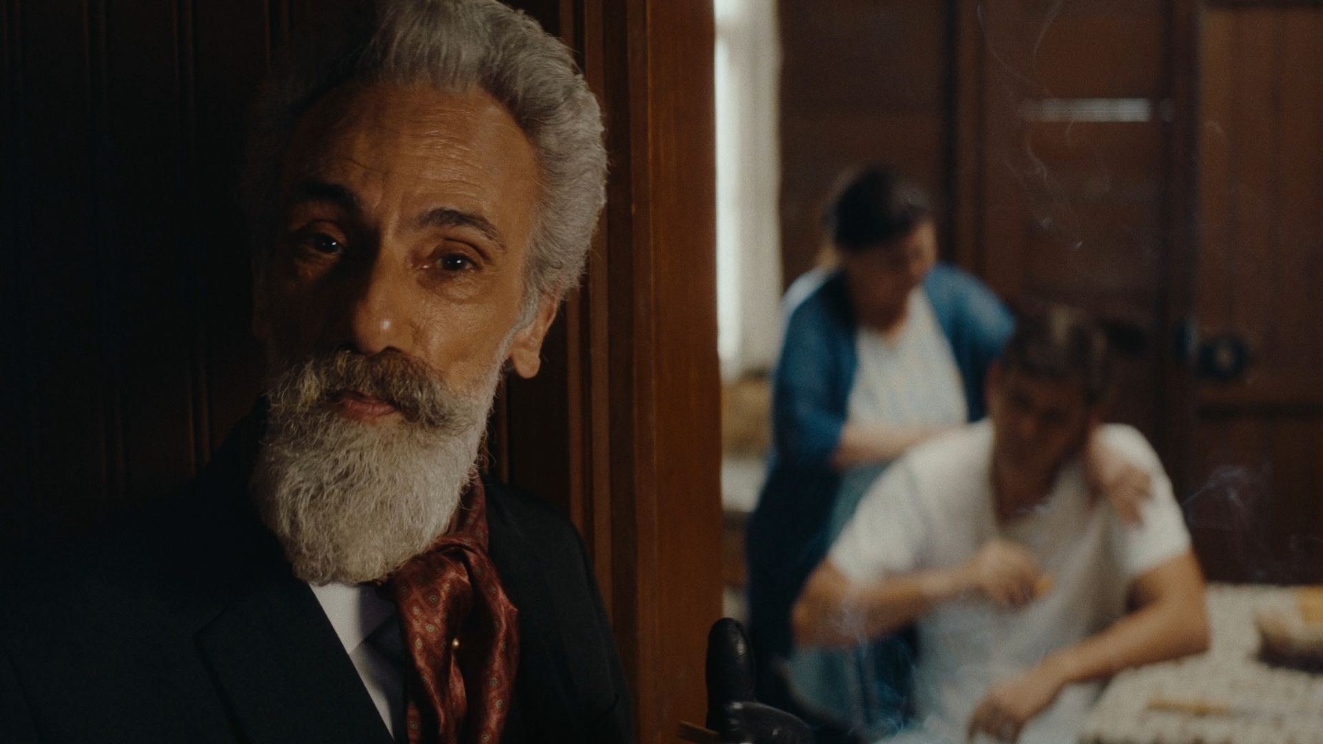 Fausto aparece em primeiro plano. Ao fundo, o protagonista Pedro com a sua mãe Maria. 