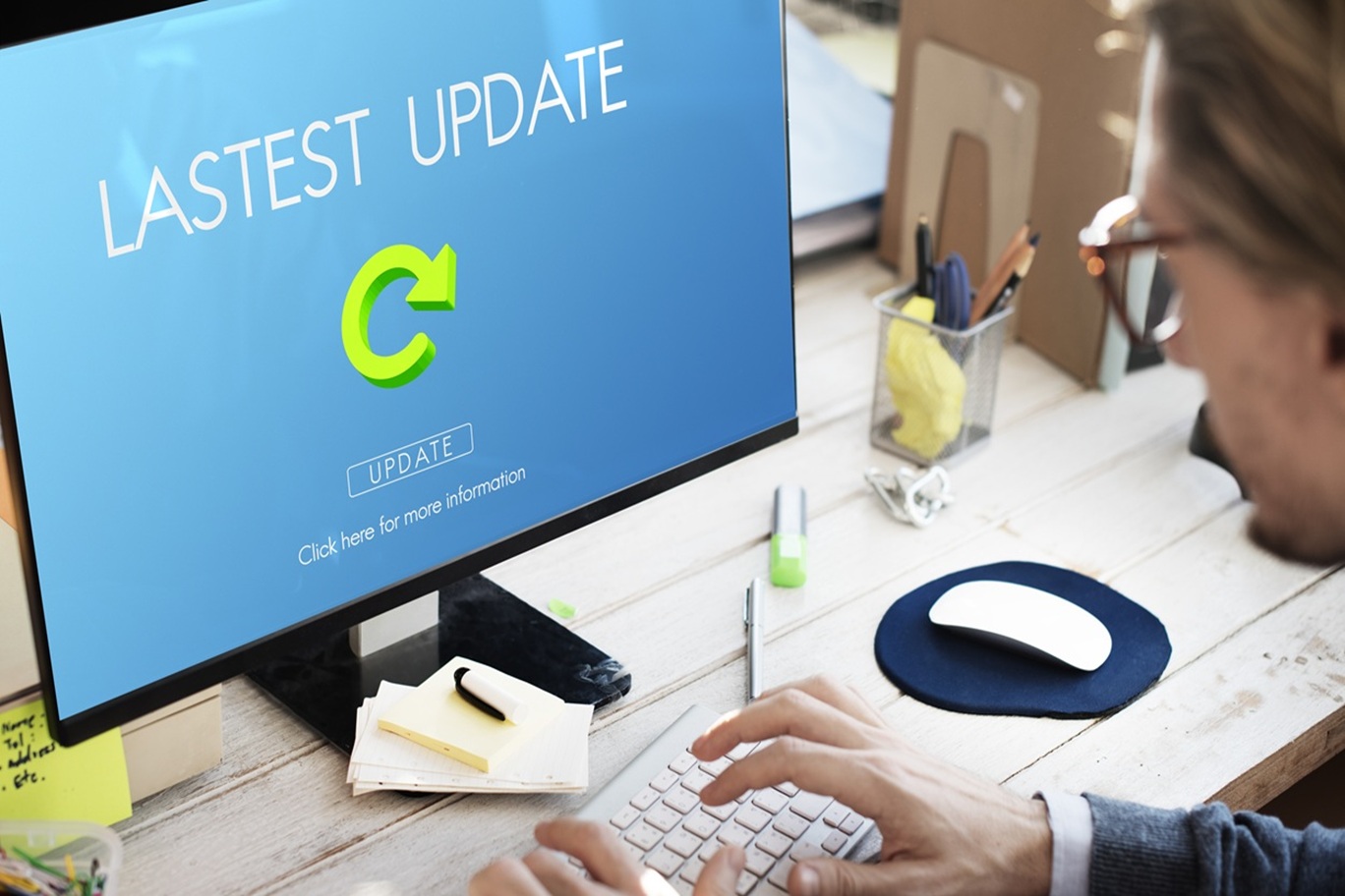 Website owner looking at a monitor showing available updates. Image from FreePik.