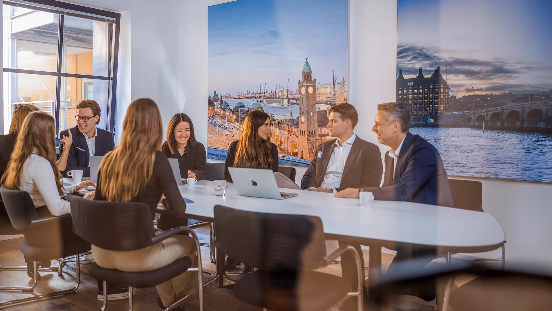 Marketing-Meeting der Attikon Finanz AG mit Blick auf den Hamburger Hafen – Business-Team im modernen Konferenzraum