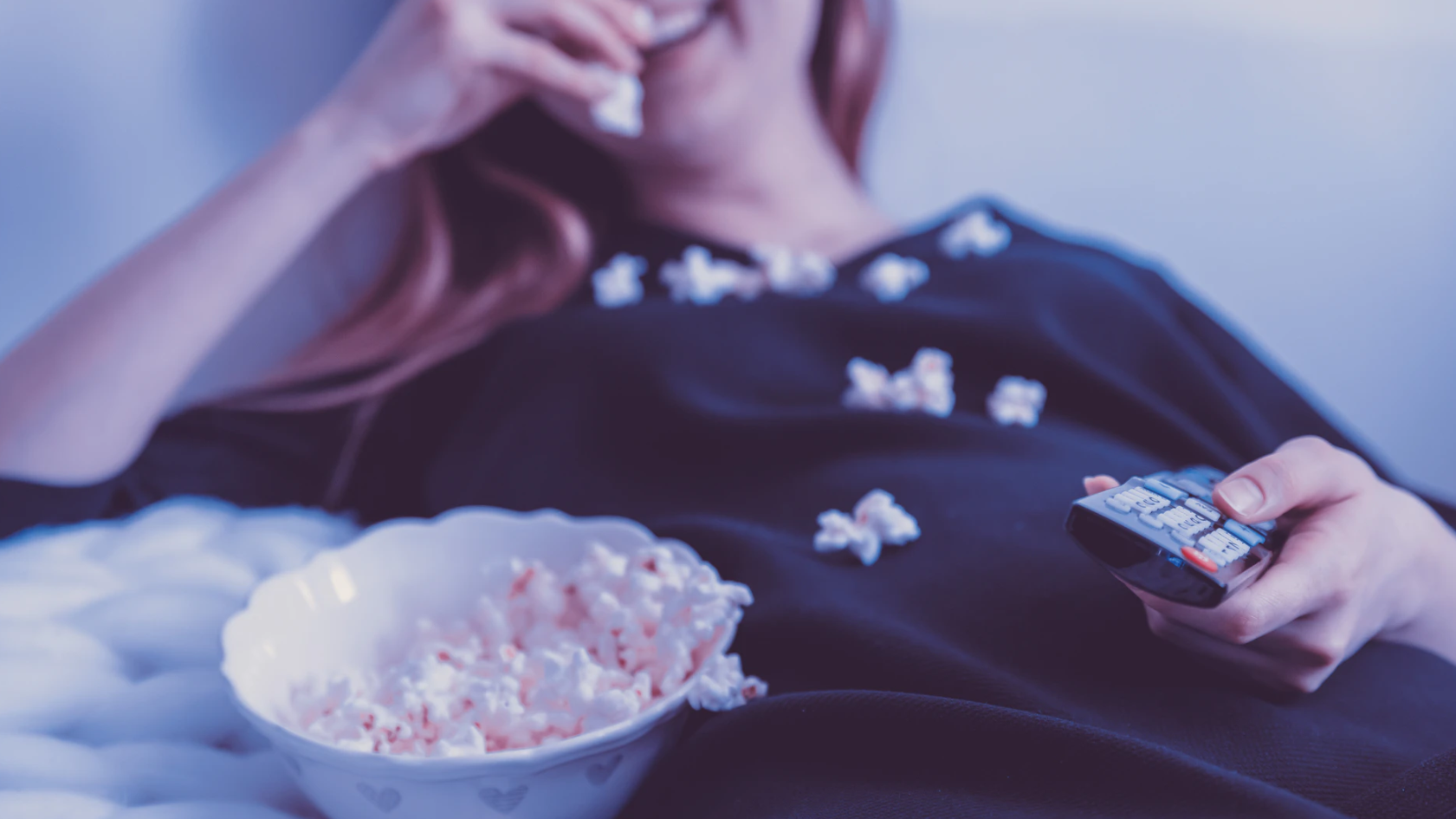 woman eating popcorn and watching TV