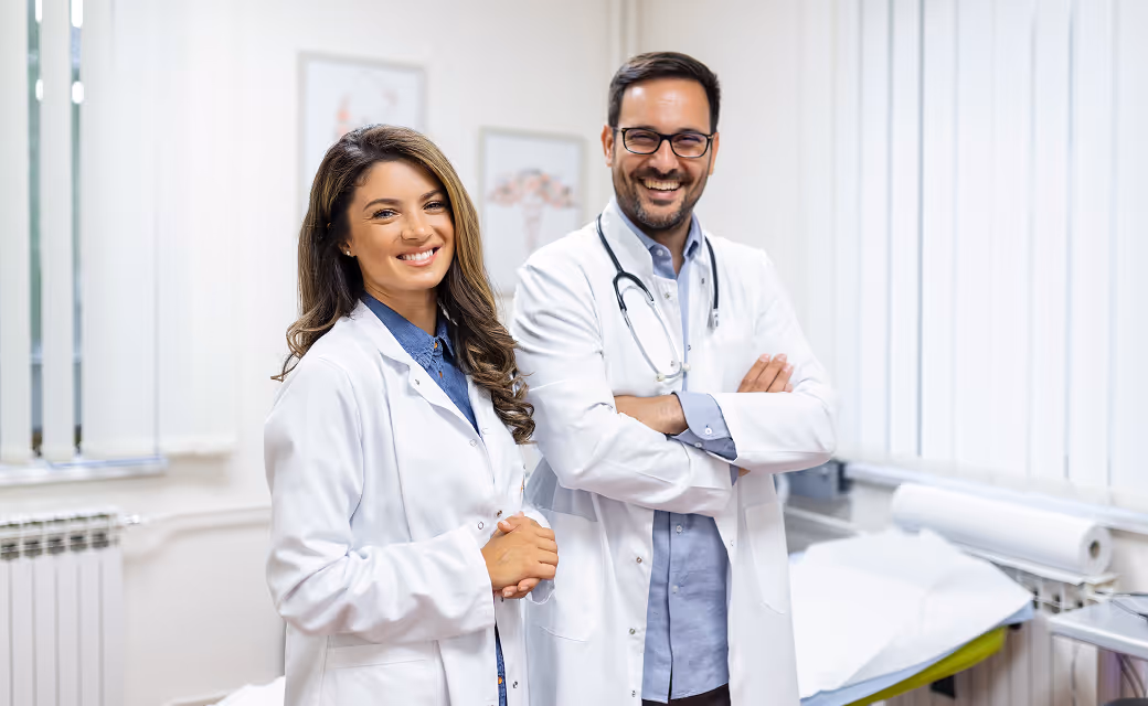 Female and male doctors standing side by side and smiling