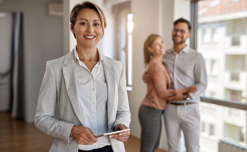 Property manager standing and smiling in front of happy tenants