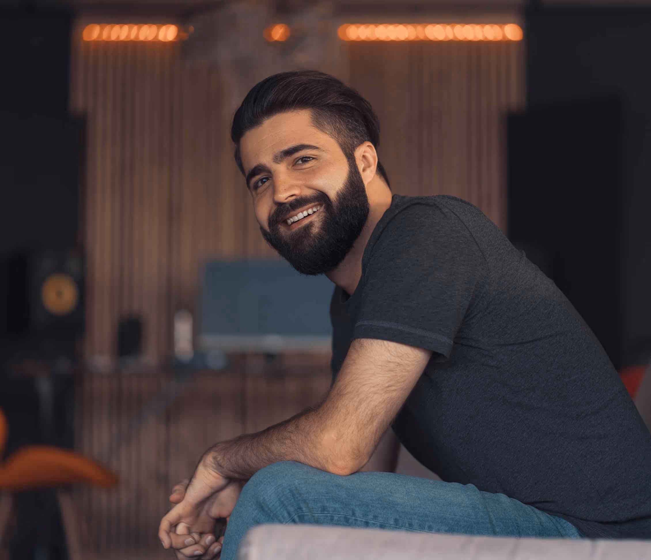 Bearded tenant smiles at phone after Adaptify sends after-hours SMS rescue that recaptures missed property leads