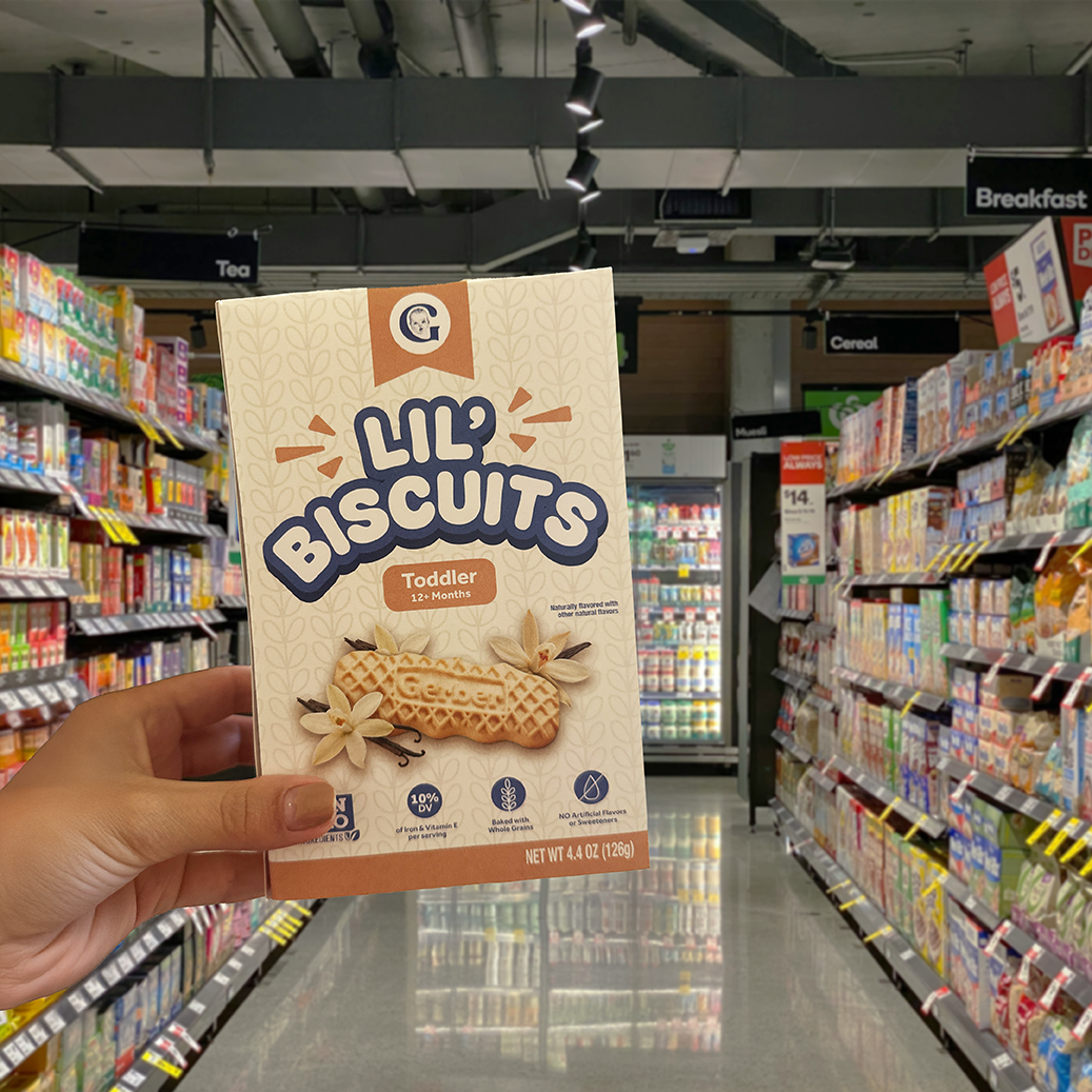 A hand holding the updated box design in the aisle of a grocery store.