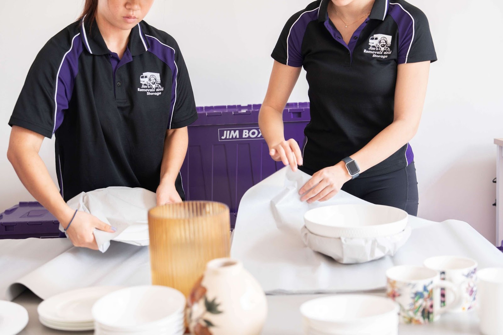 two packers wrapping fragile items in butcher's paper