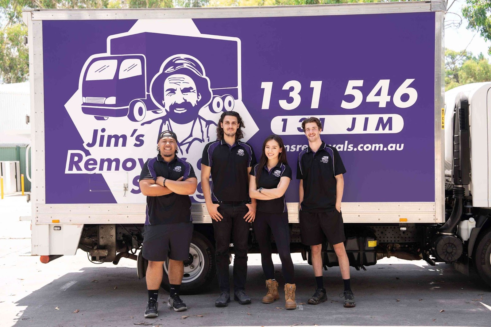 Jim's Removals team standing in front of a purple moving truck