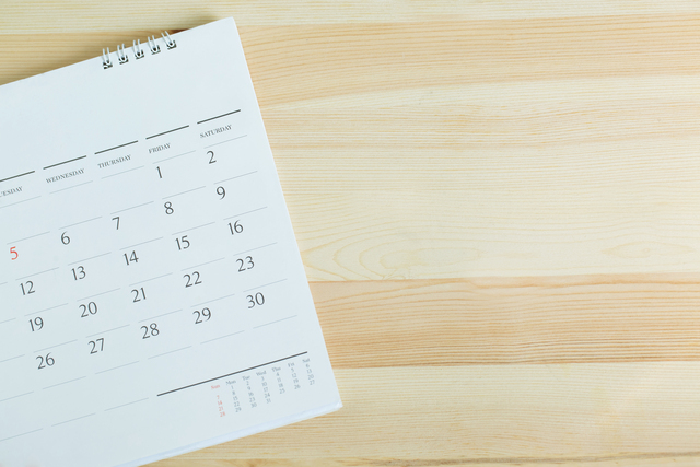 a calendar with dates on a wooden table